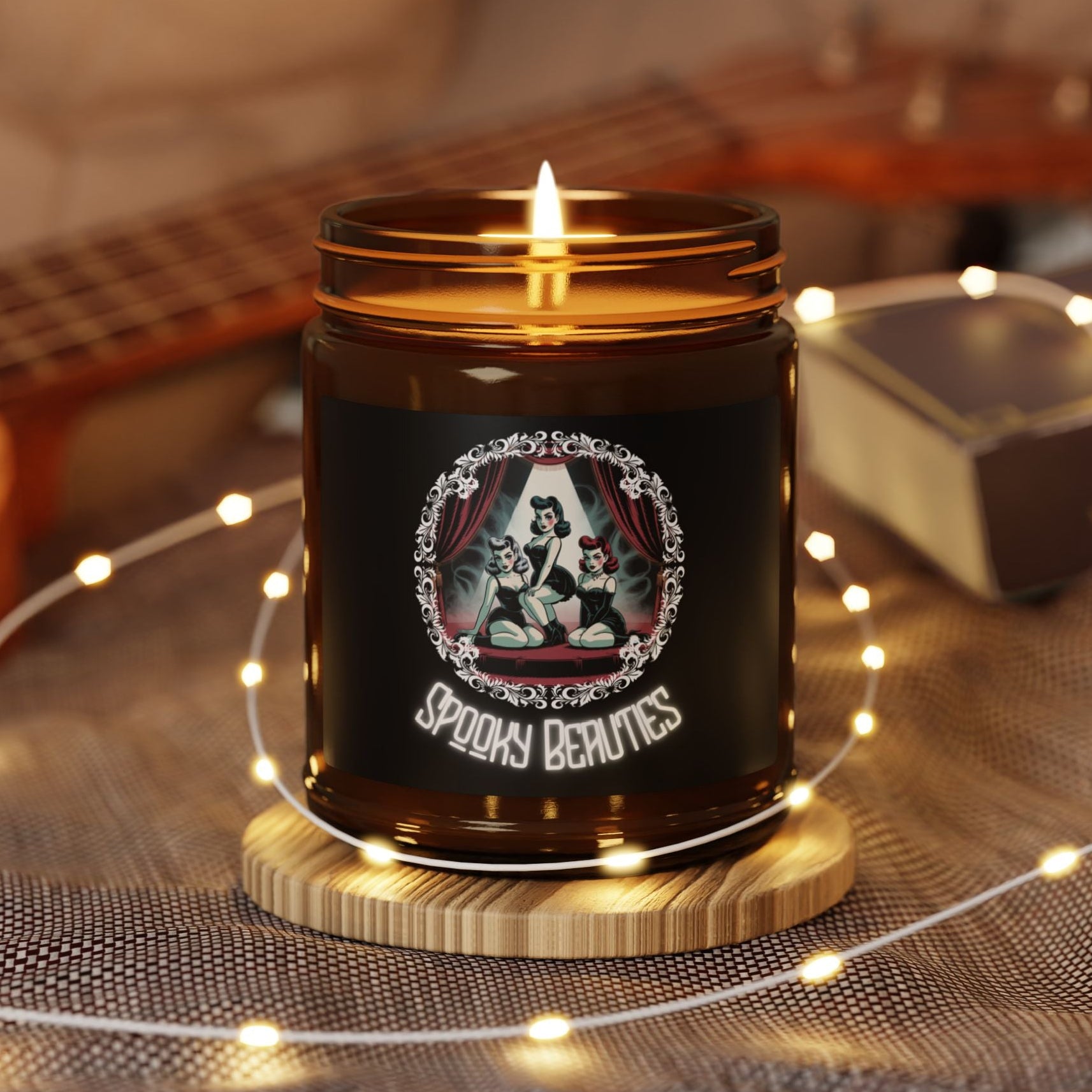 Candle in a jar with a decorative label on a wooden coaster, surrounded by string lights and a guitar in the background.