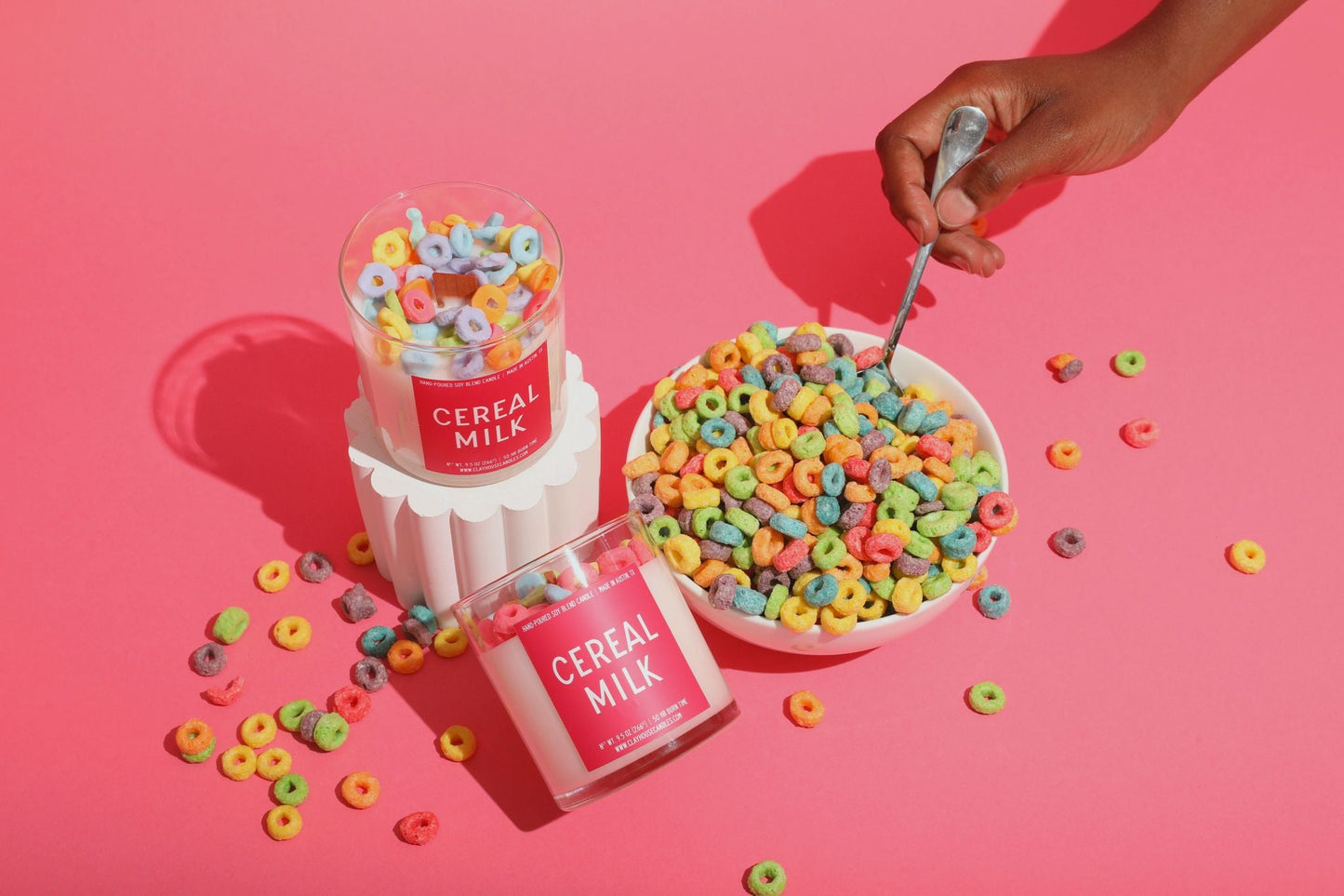 Cereal Milk packaging with a bowl of cereal and colorful cereal loops on a pink background
